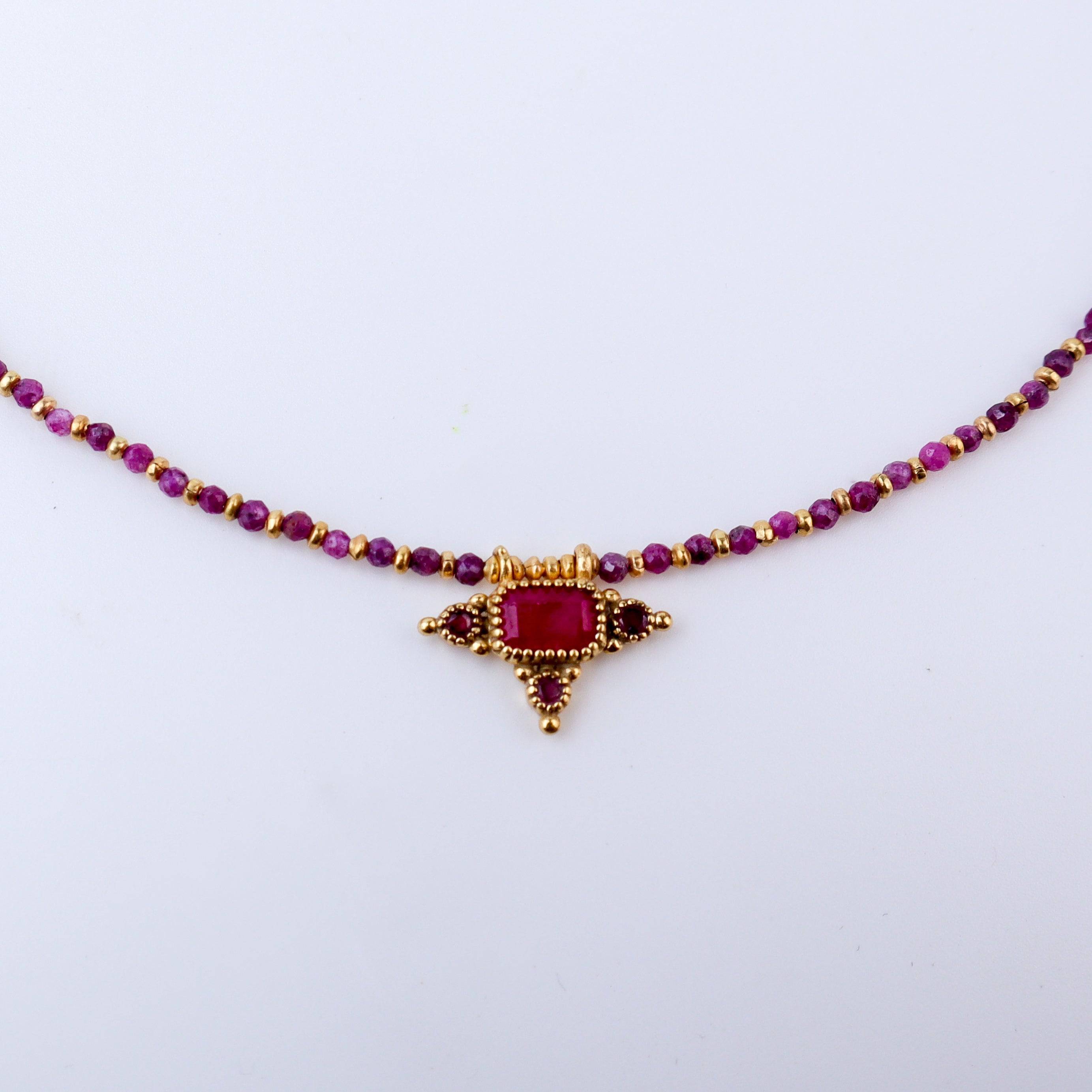 Close-up of a brass fashion necklace showcasing intricate detailing, textured elements, and fine craftsmanship