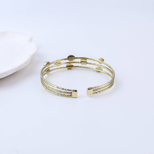 Detailed view of the brass fashion bracelet highlighting intricate motifs, textured surface, and refined brass finish