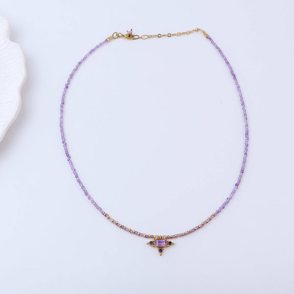 Detailed view of a brass fashion necklace highlighting intricate motifs, textured surface, and refined brass finish