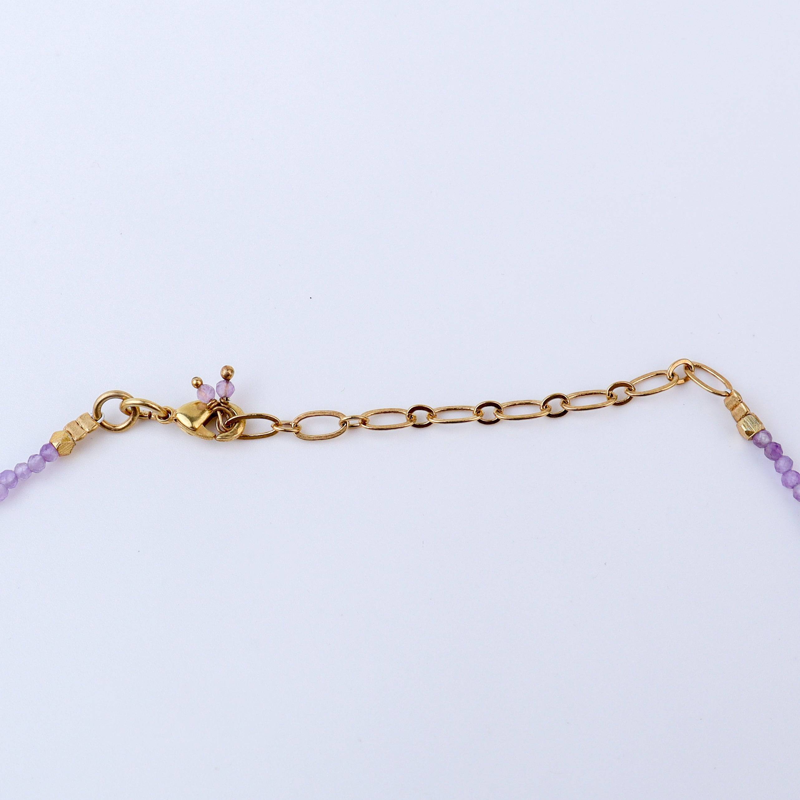 Angled view of a brass fashion necklace highlighting its unique silhouette, structure, and polished brass finish