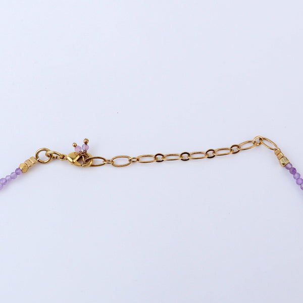 Angled view of a brass fashion necklace highlighting its unique silhouette, structure, and polished brass finish