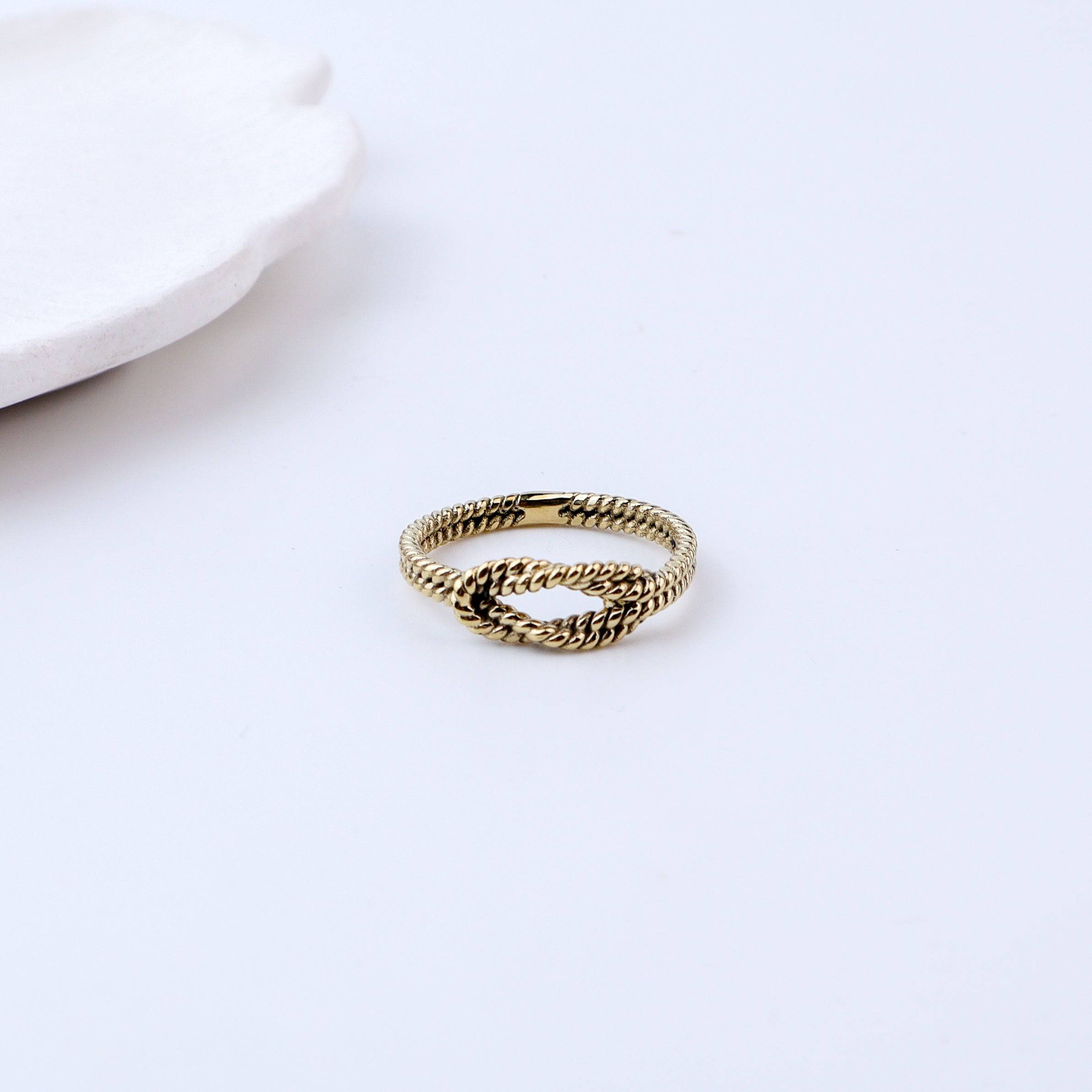 Flat-lay of a brass fashion ring with complementary jewellery and accessories for a chic styling setup