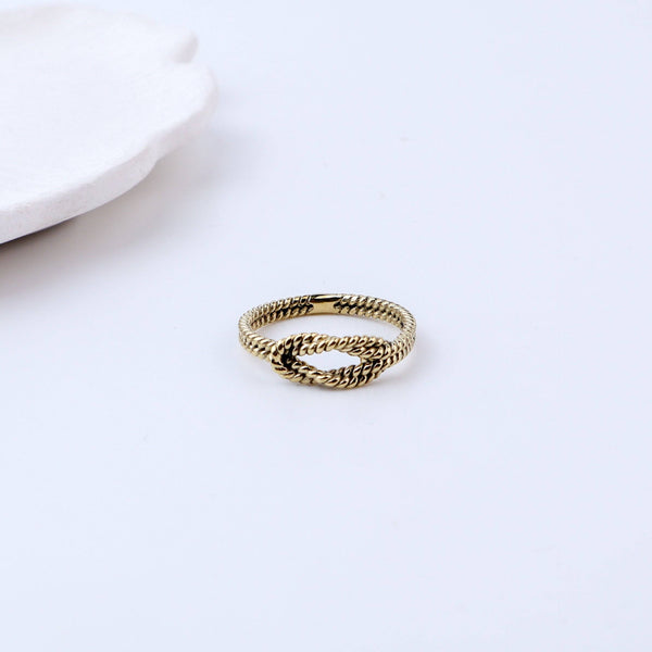 Flat-lay of a brass fashion ring with complementary jewellery and accessories for a chic styling setup