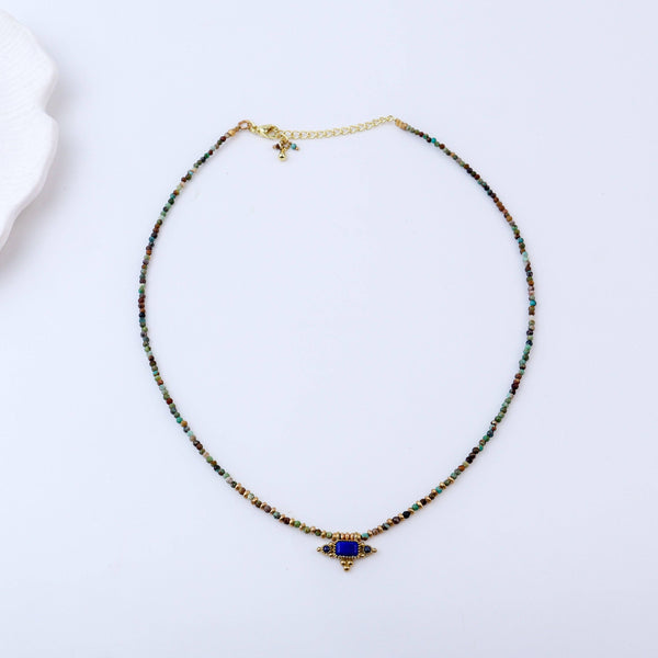 Detailed view of a brass fashion necklace highlighting intricate motifs, textured surface, and refined brass finish
