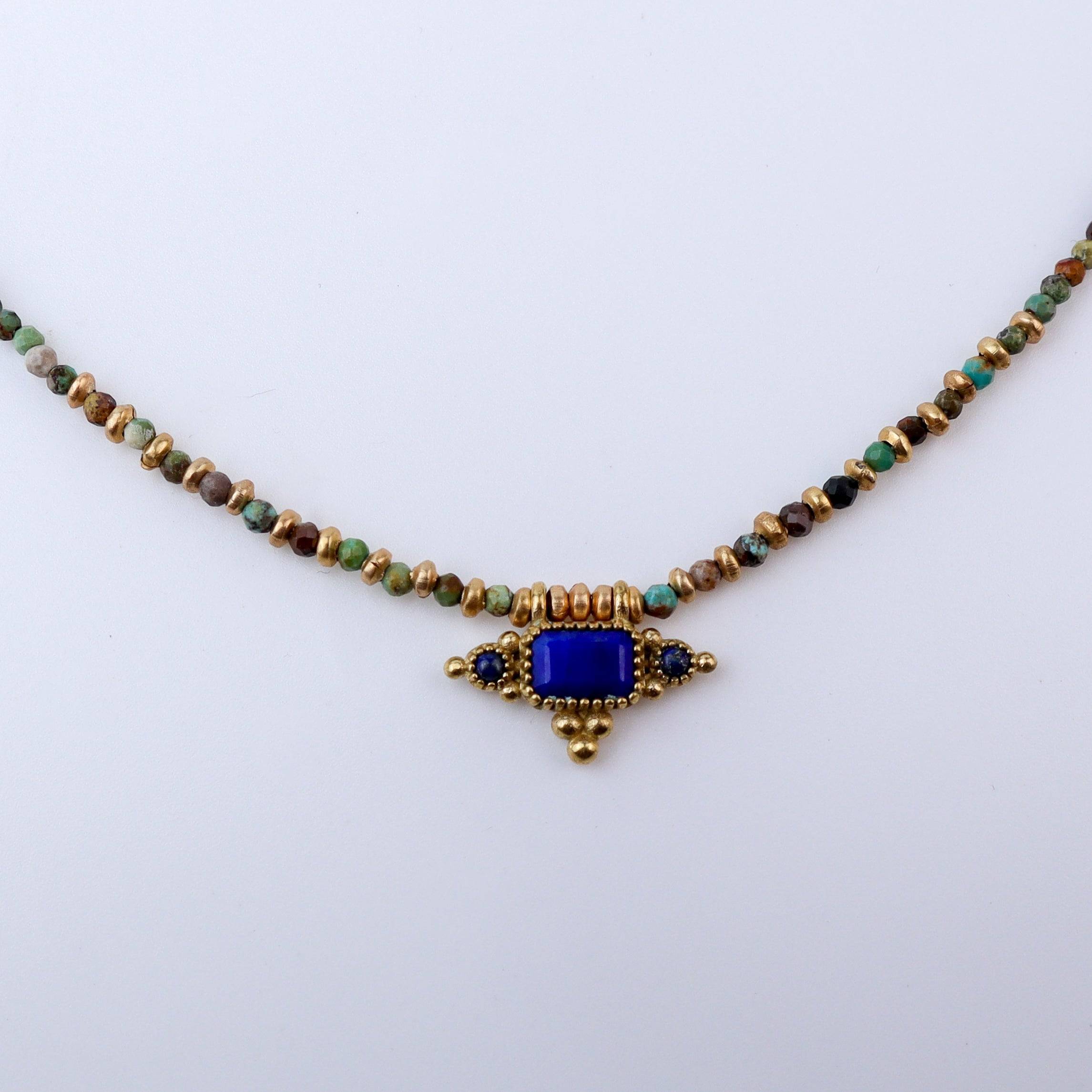 Close-up of a brass fashion necklace showcasing intricate detailing, textured elements, and fine craftsmanship