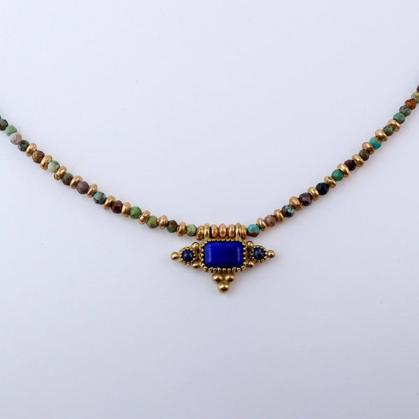 Close-up of a brass fashion necklace showcasing intricate detailing, textured elements, and fine craftsmanship