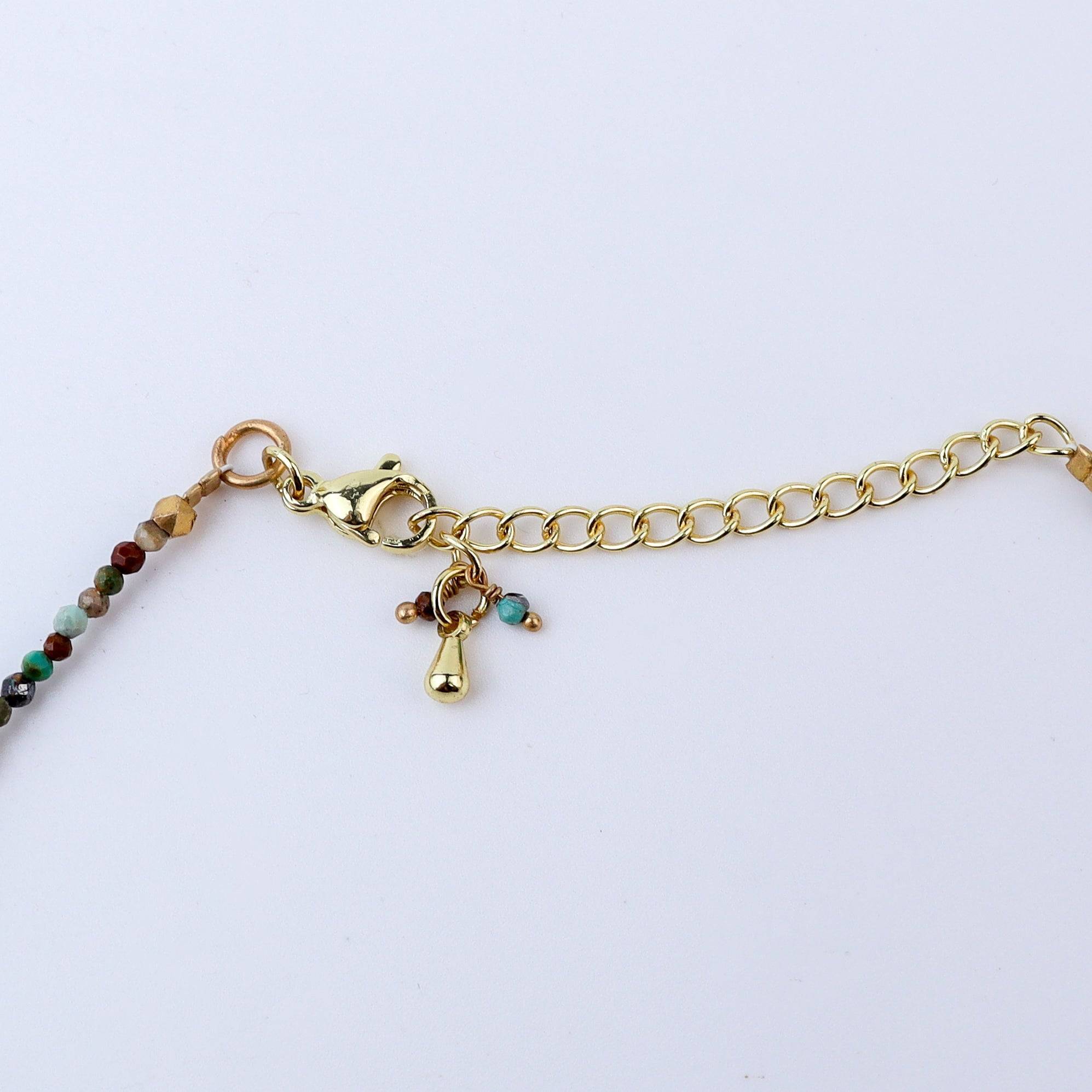 Angled view of a brass fashion necklace highlighting its unique silhouette, structure, and polished brass finish