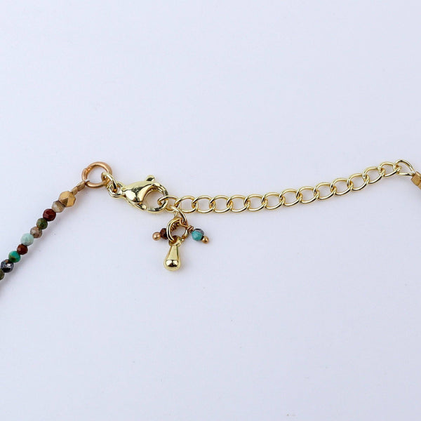 Angled view of a brass fashion necklace highlighting its unique silhouette, structure, and polished brass finish