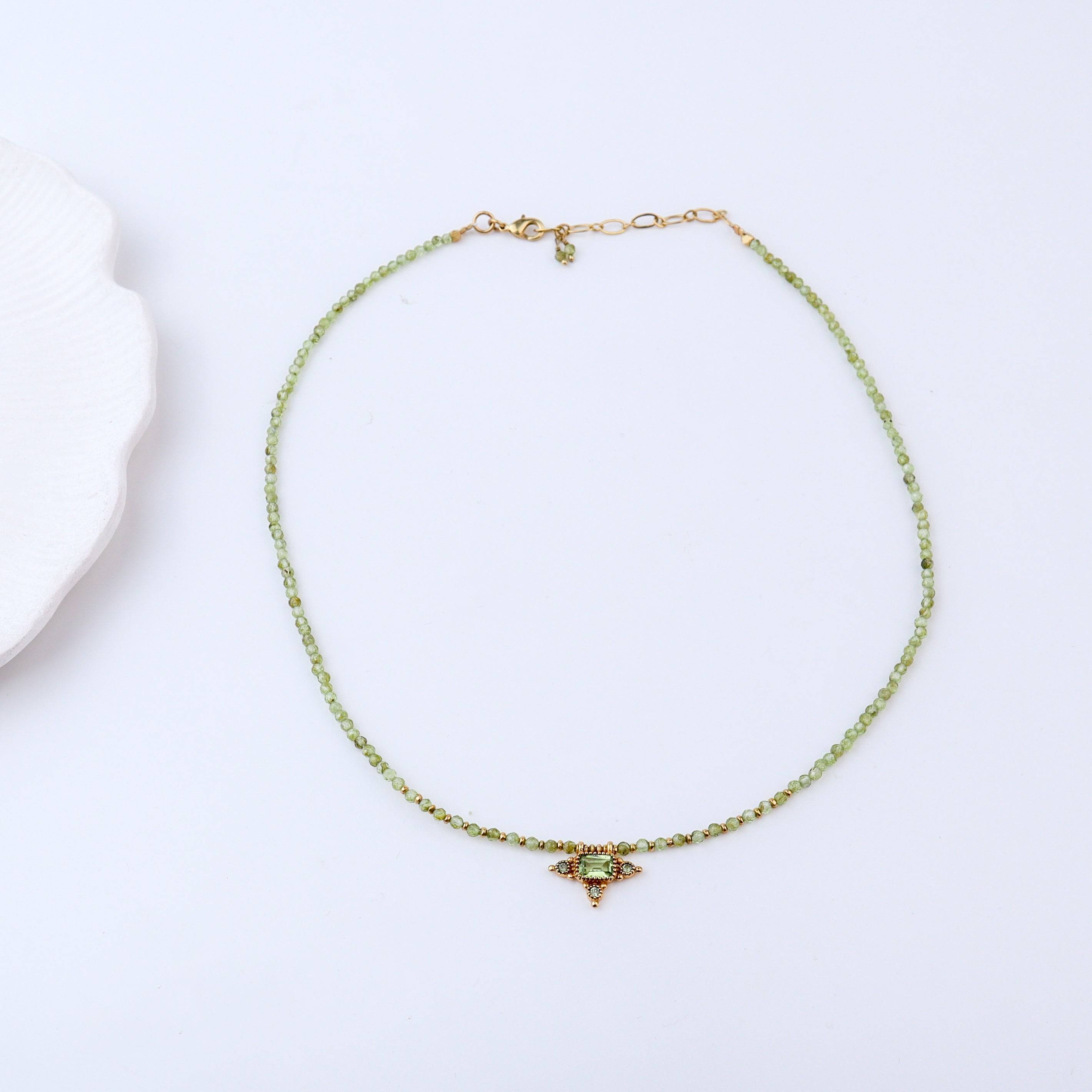 Detailed view of a brass fashion necklace highlighting intricate motifs, textured surface, and refined brass finish