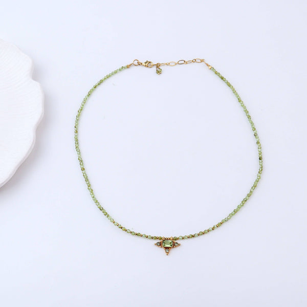 Detailed view of a brass fashion necklace highlighting intricate motifs, textured surface, and refined brass finish