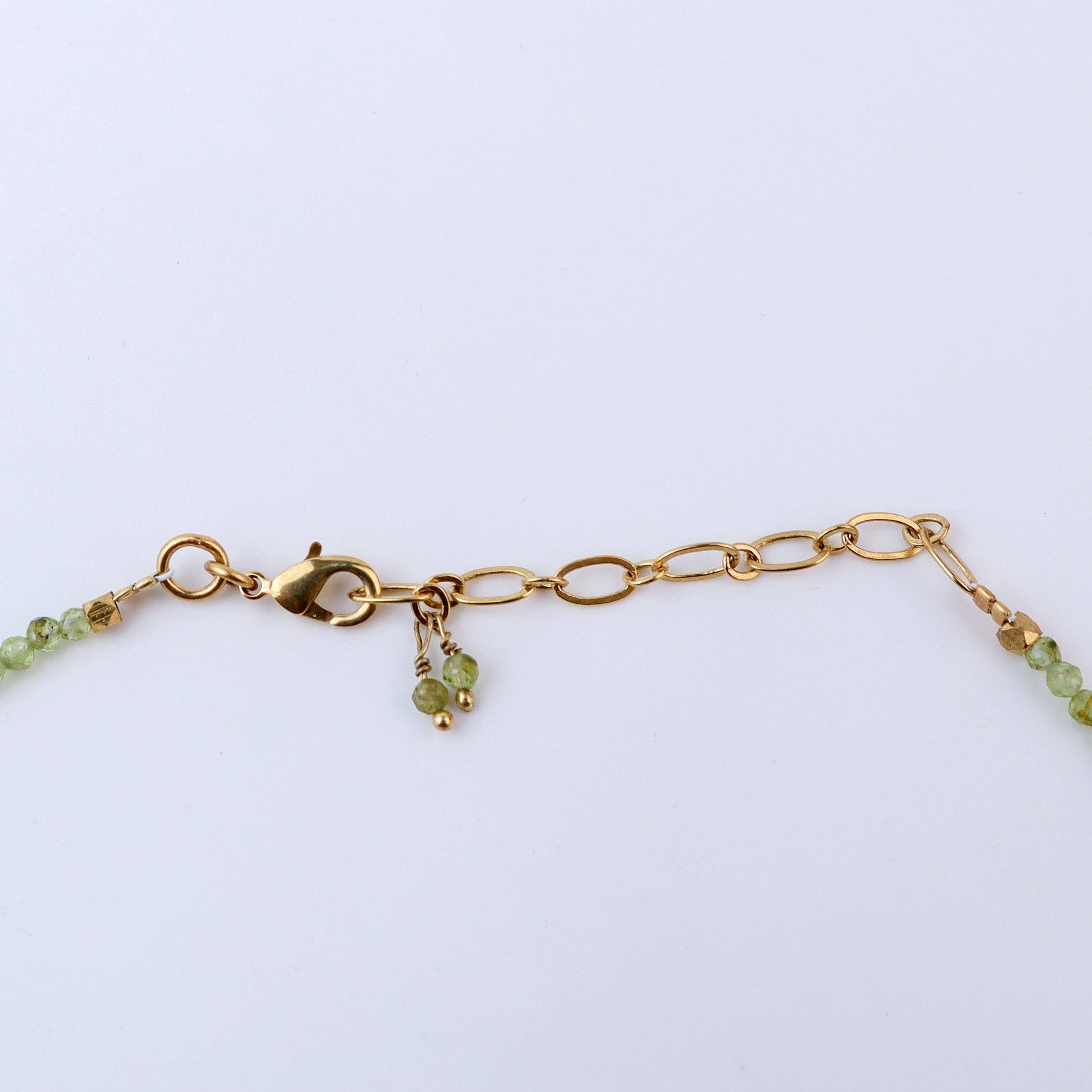 Angled view of a brass fashion necklace highlighting its unique silhouette, structure, and polished brass finish