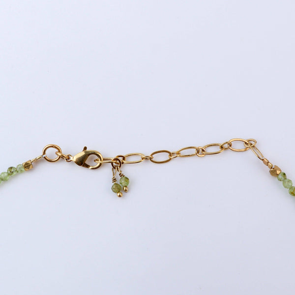 Angled view of a brass fashion necklace highlighting its unique silhouette, structure, and polished brass finish