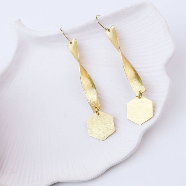 Close-up of brass fashion earrings showcasing intricate detailing, textured elements, and fine craftsmanship
