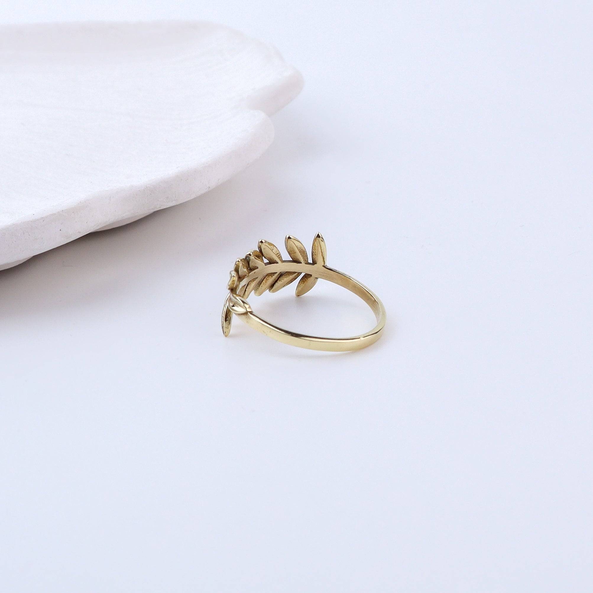 Angled view of a brass fashion ring highlighting its distinctive shape, structure, and polished brass finish