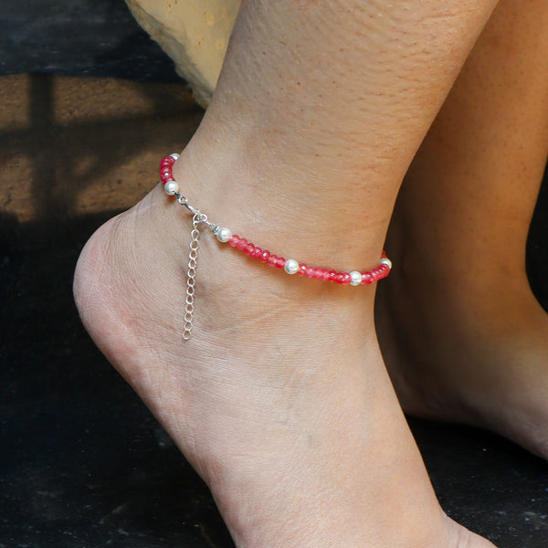 Close-up of pink beaded anklet with silver chain and white pearls