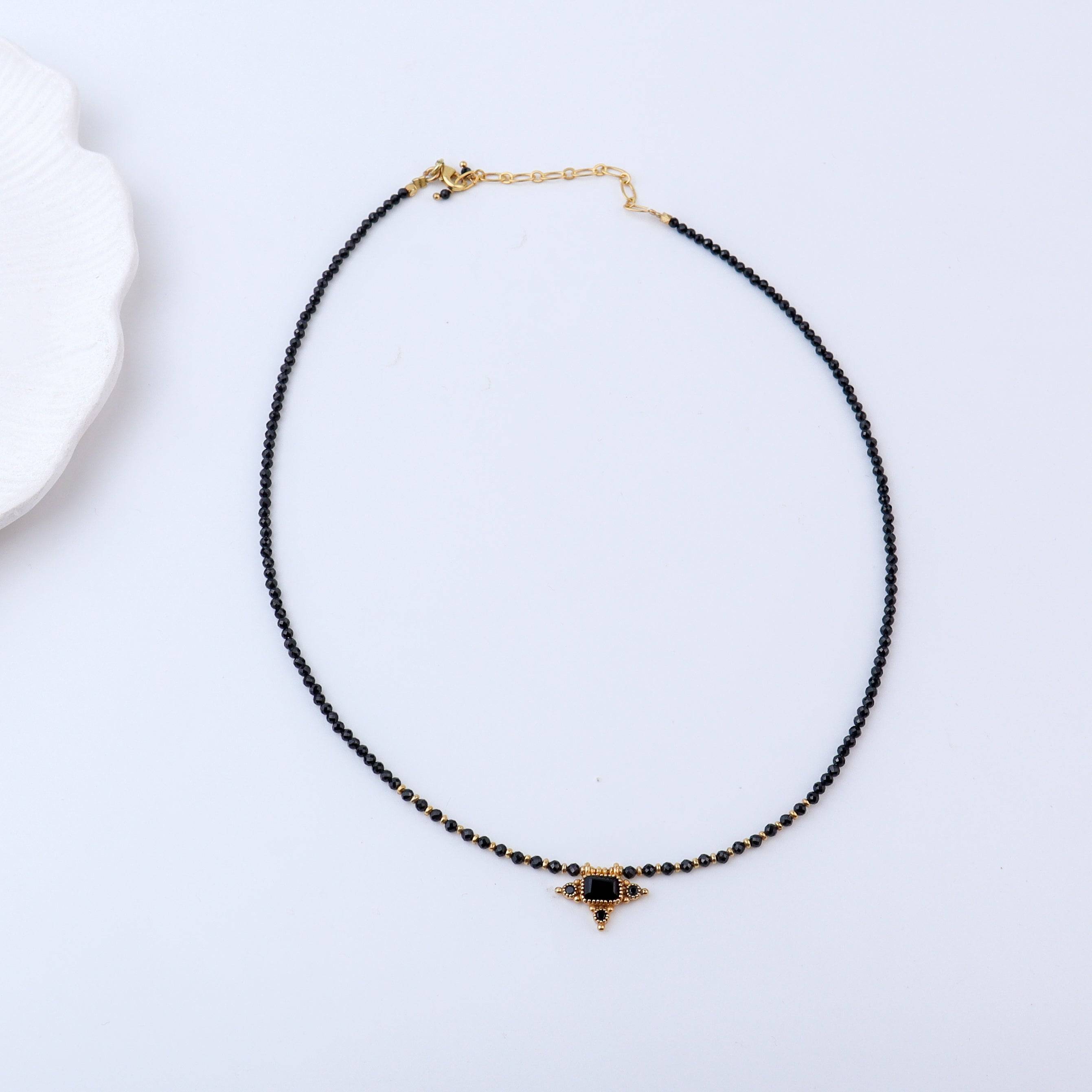 Detailed view of a brass fashion necklace highlighting intricate motifs, textured surface, and refined brass finish
