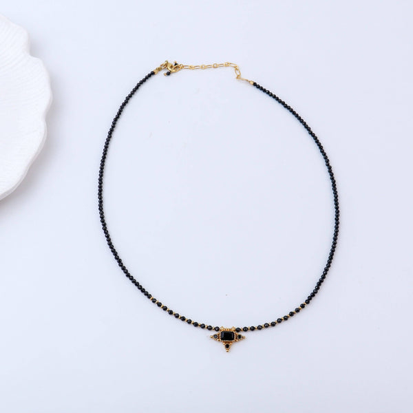 Detailed view of a brass fashion necklace highlighting intricate motifs, textured surface, and refined brass finish