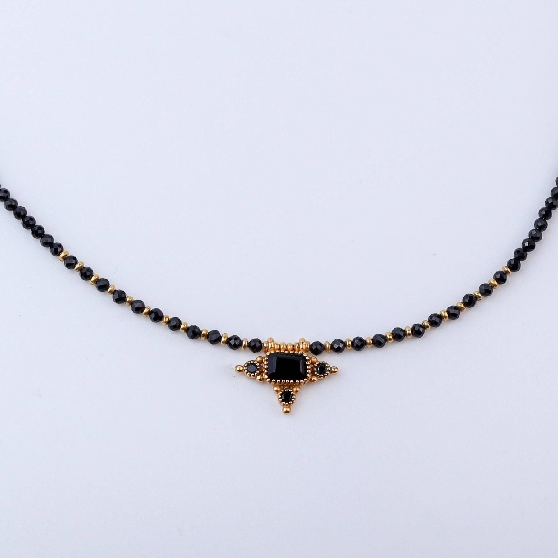 Close-up of a brass fashion necklace showcasing intricate detailing, textured elements, and fine craftsmanship