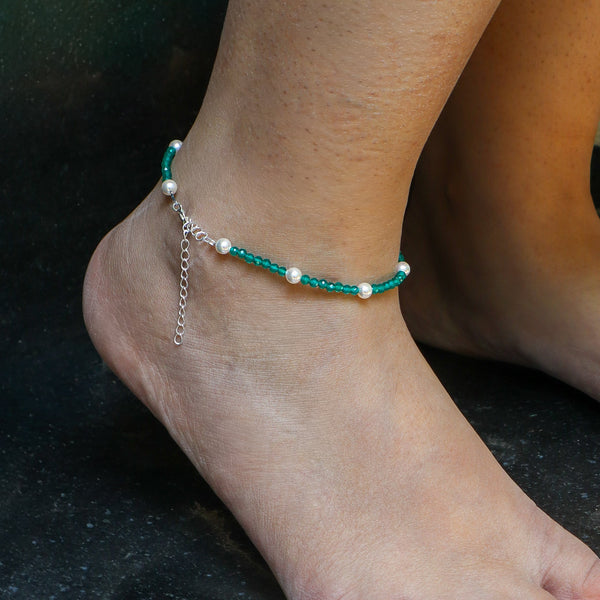 Close-up of turquoise and pearl beaded anklet on ankle