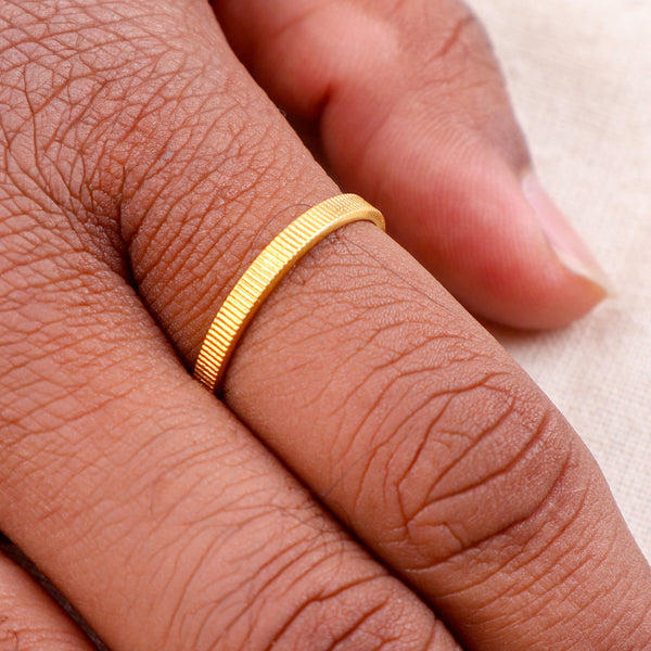 Close-up of textured gold ring on finger