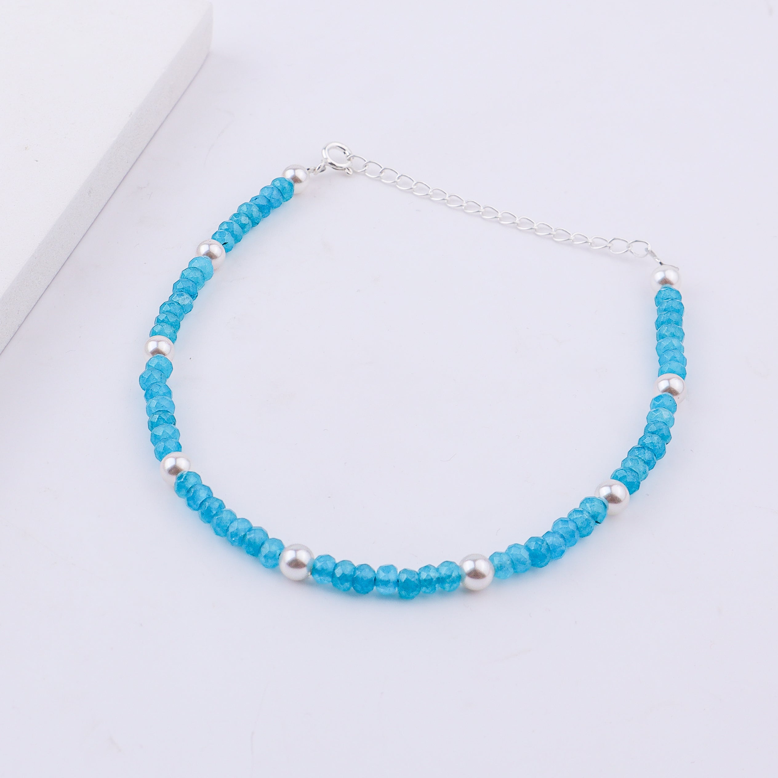 Blue beaded anklet with pearls on white background
