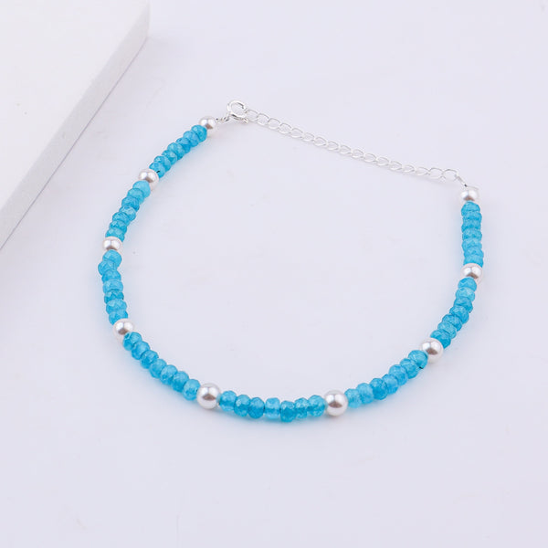 Blue beaded anklet with pearls on white background