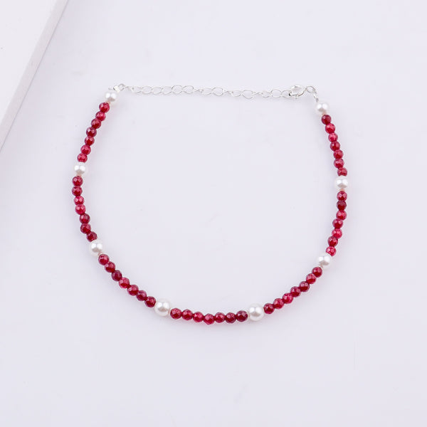 Close-up of red beaded and pearl anklet