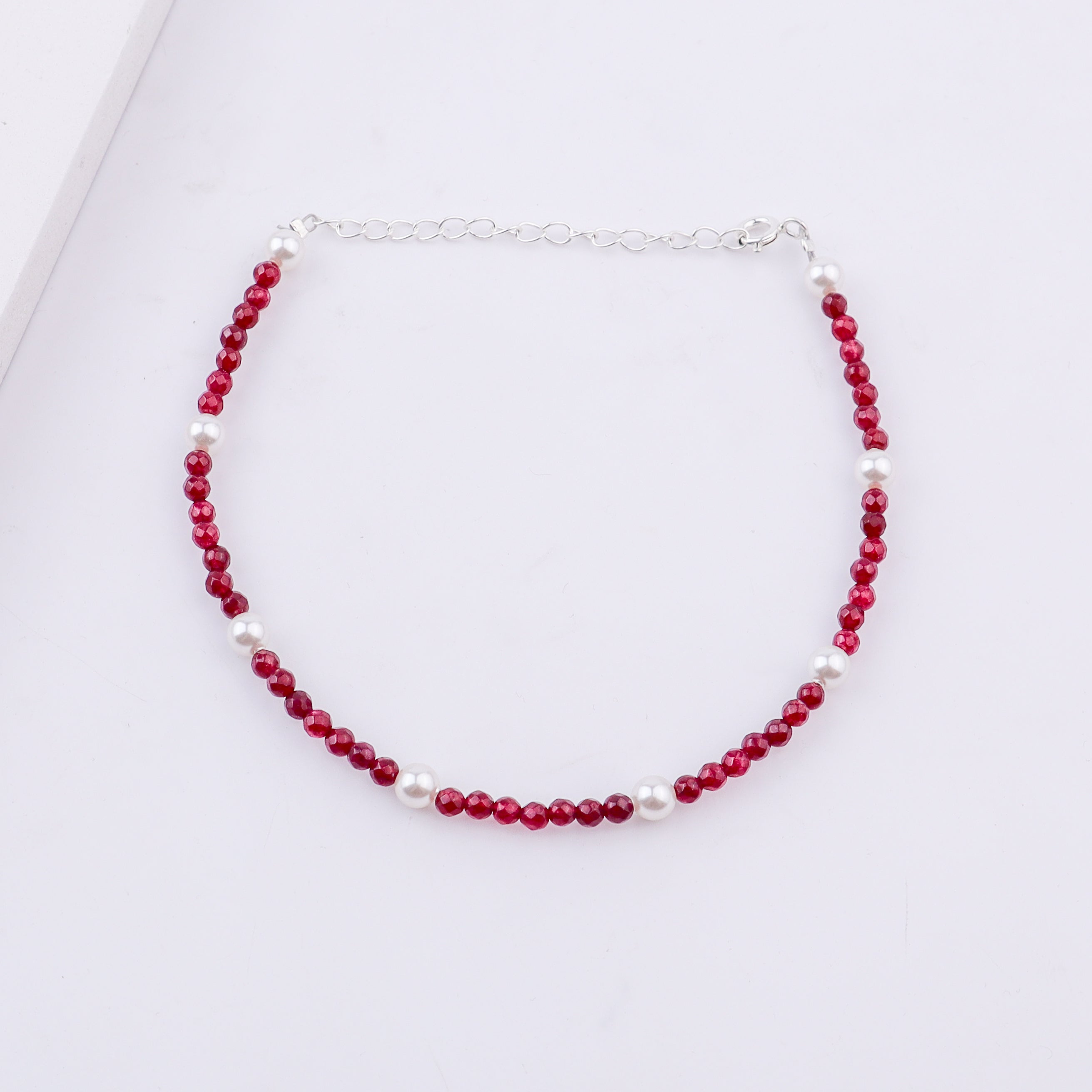 Close-up of red beaded and pearl anklet