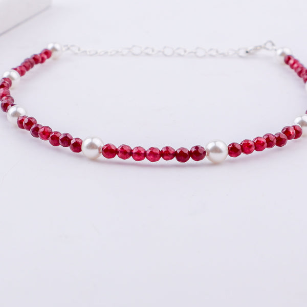 White pearls and red beads anklet on foot
