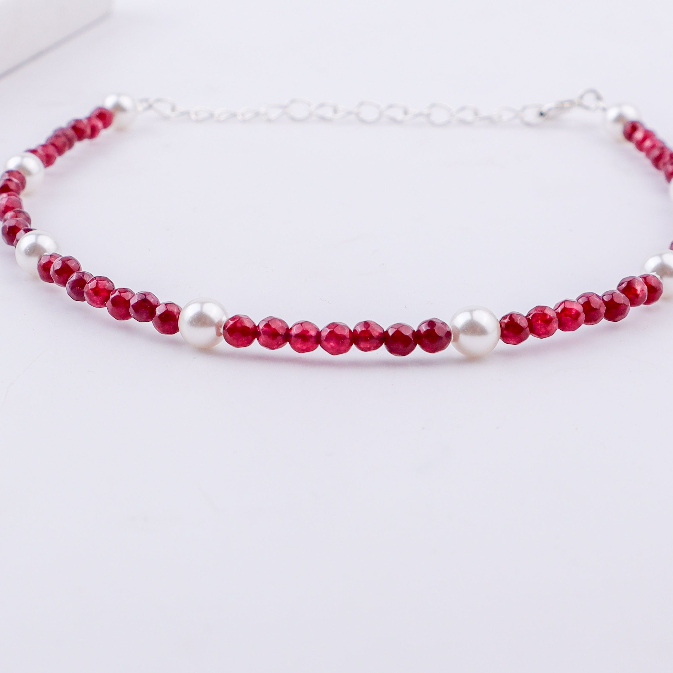 White pearls and red beads anklet on foot