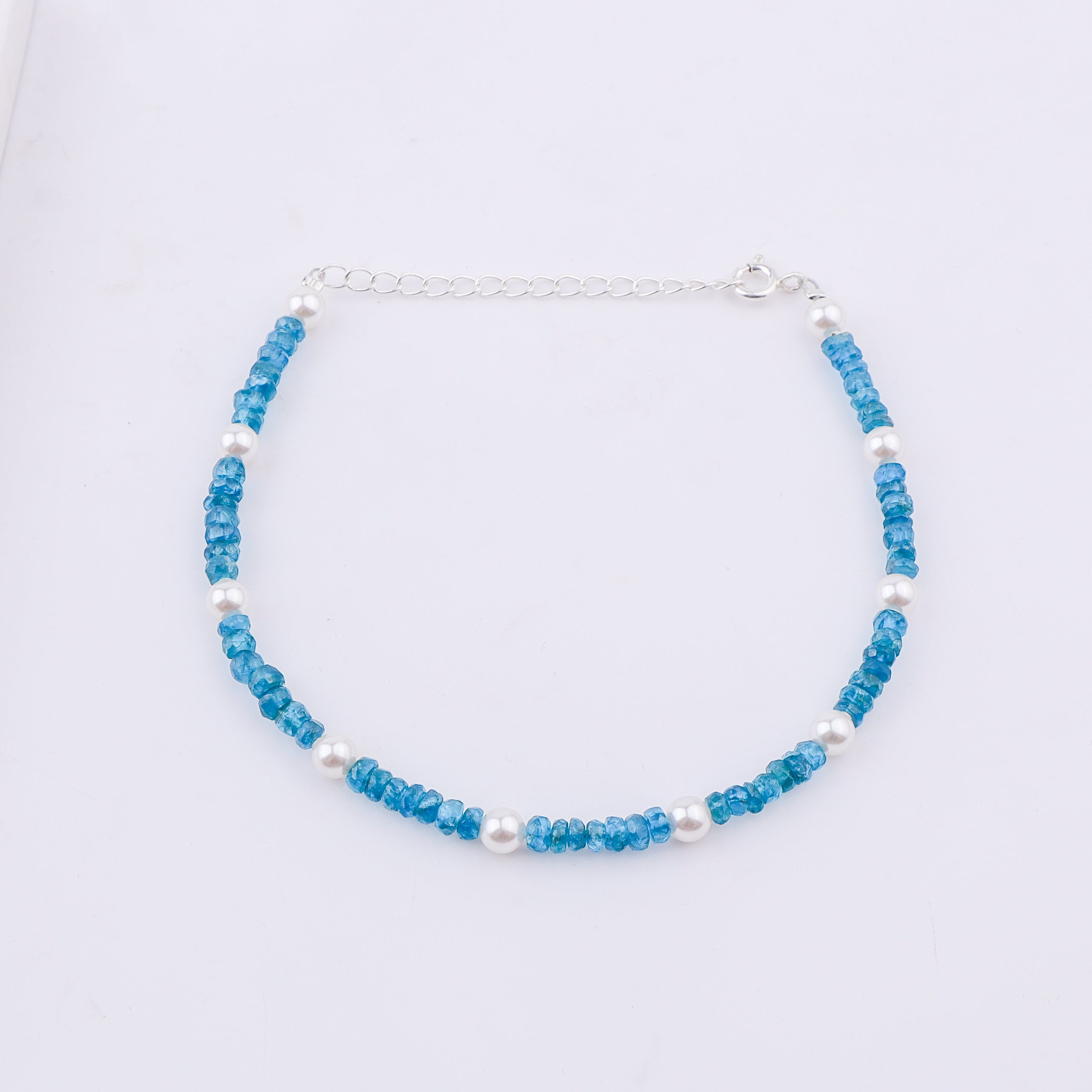 Blue beaded anklet with pearls on white background