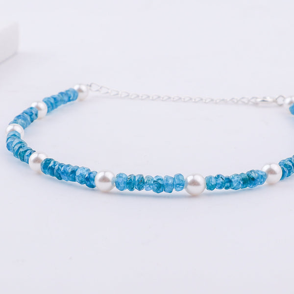 White background showing blue beaded anklet with pearls