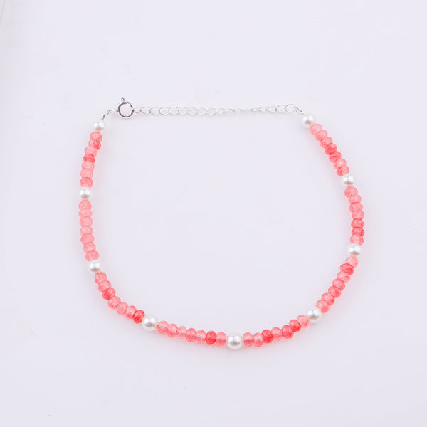 Pink beaded anklet with white pearls and silver chain on ankle