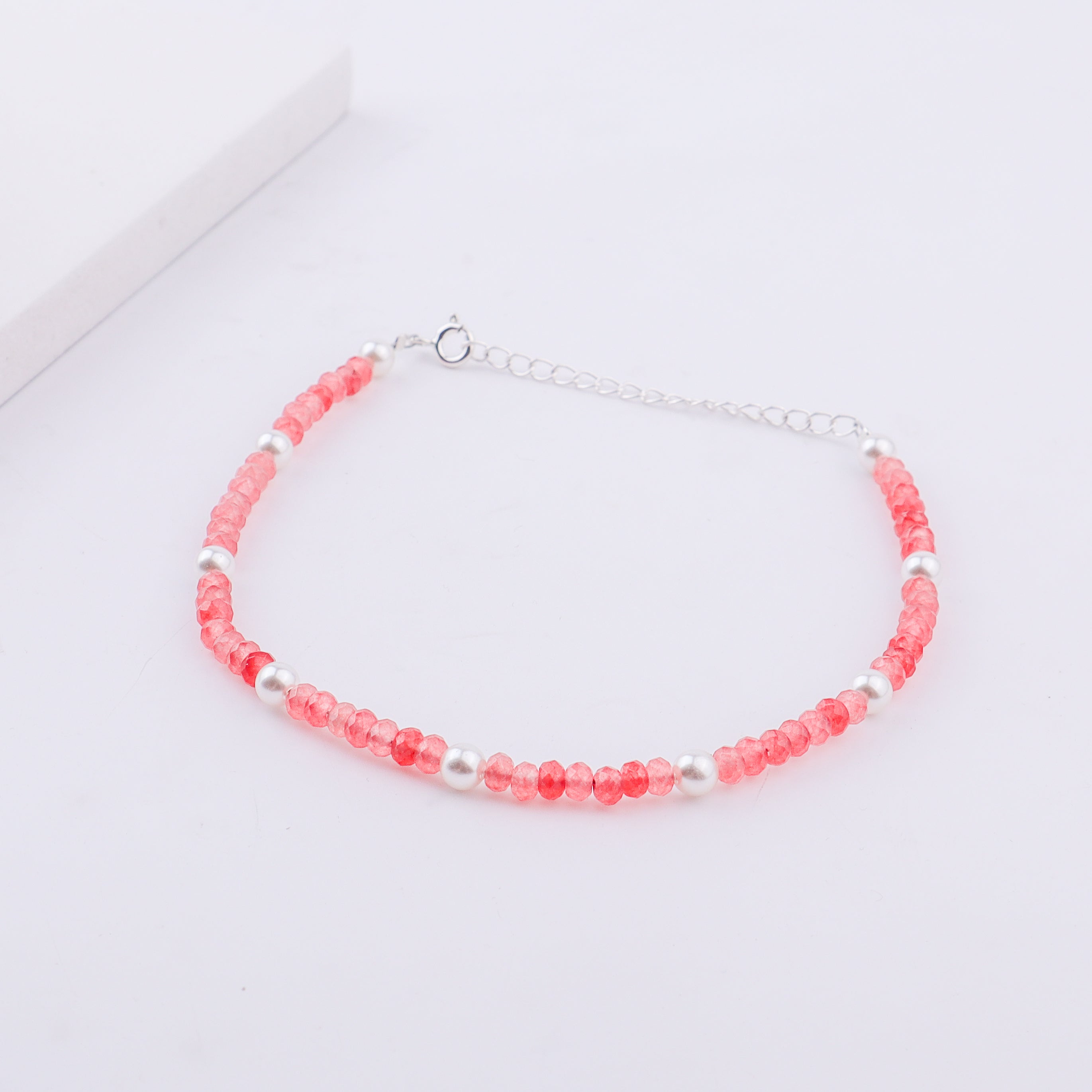 Pink beaded anklet with white pearls and silver chain on ankle