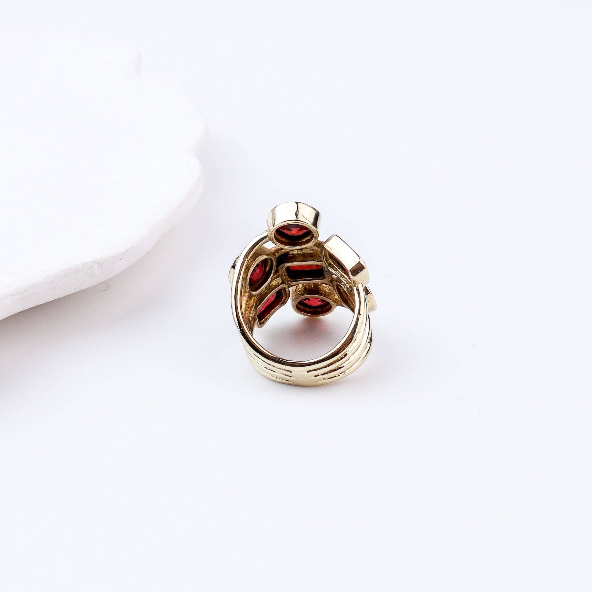 Angled view of a brass fashion ring highlighting its distinctive shape, structure, and polished brass finish