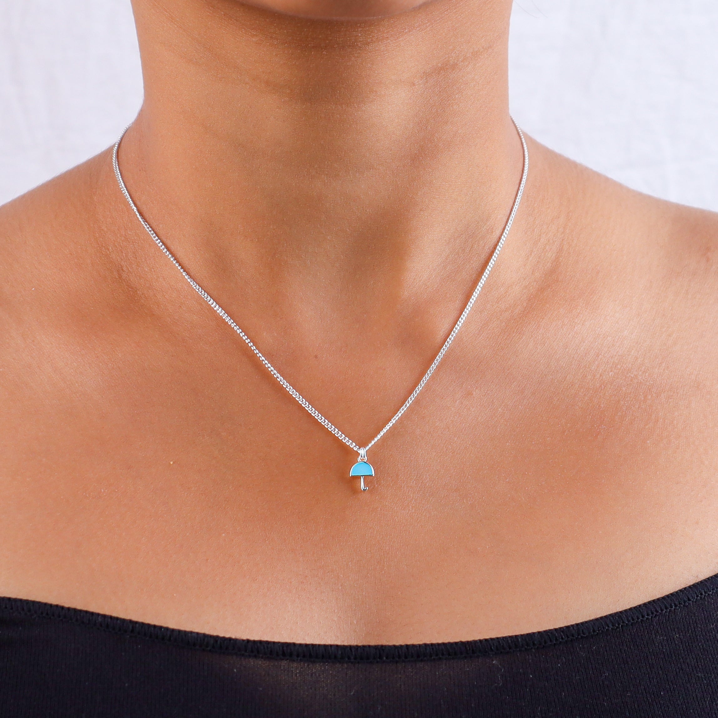 Silver umbrella pendant necklace on neck