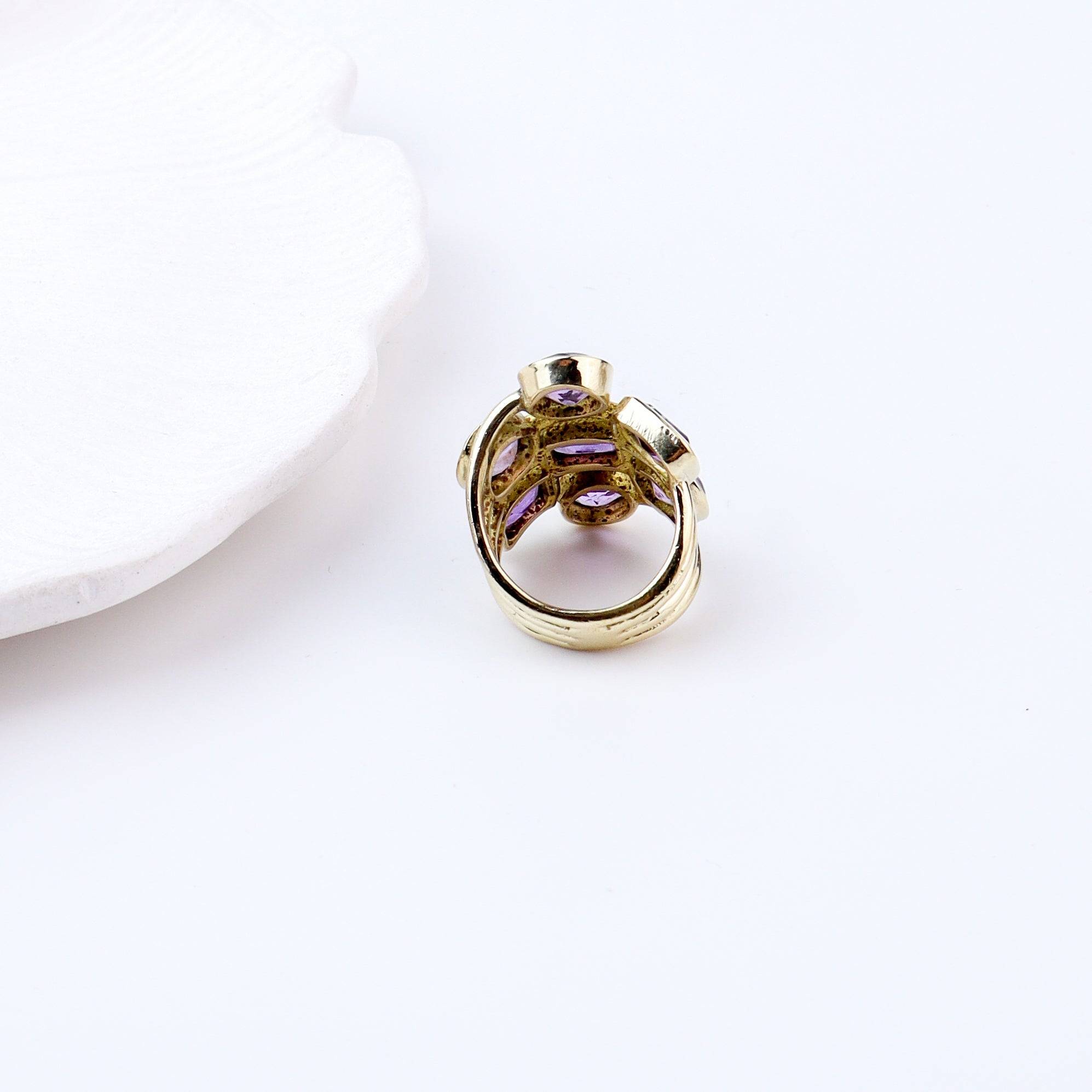 Flat-lay of a brass fashion ring with complementary jewellery and accessories for a chic styling setup