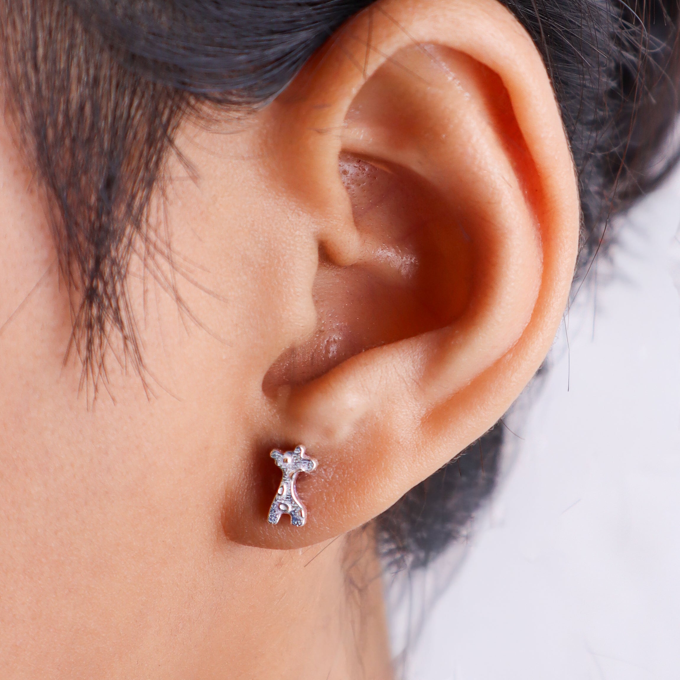 Woman wearing silver giraffe earrings with close-up