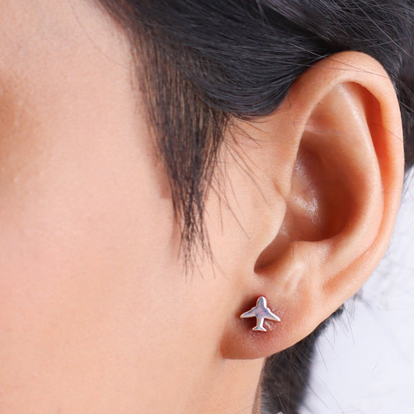 Woman wearing airplane silver studs earrings near ear