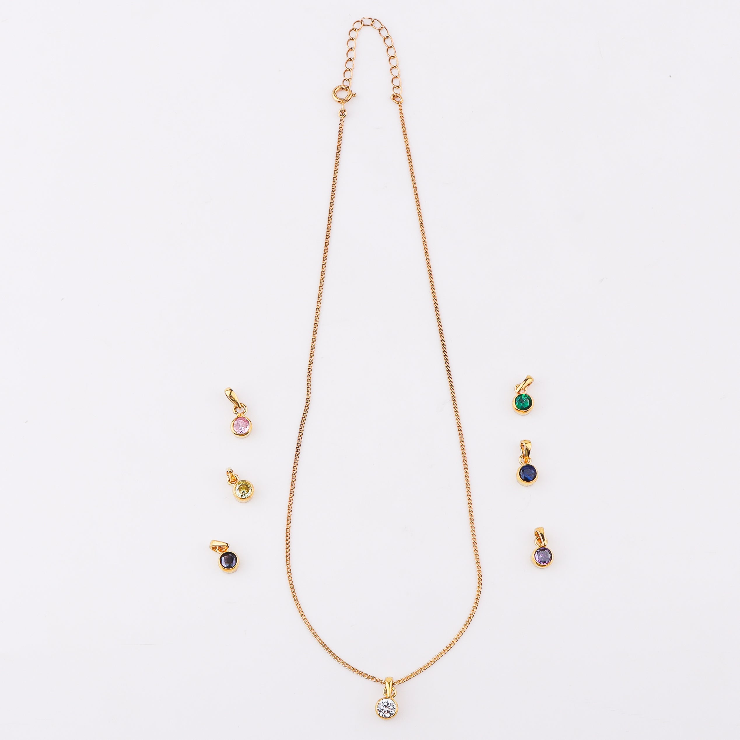 Gold chain jewelry with black cubic zirconia pendant on white background