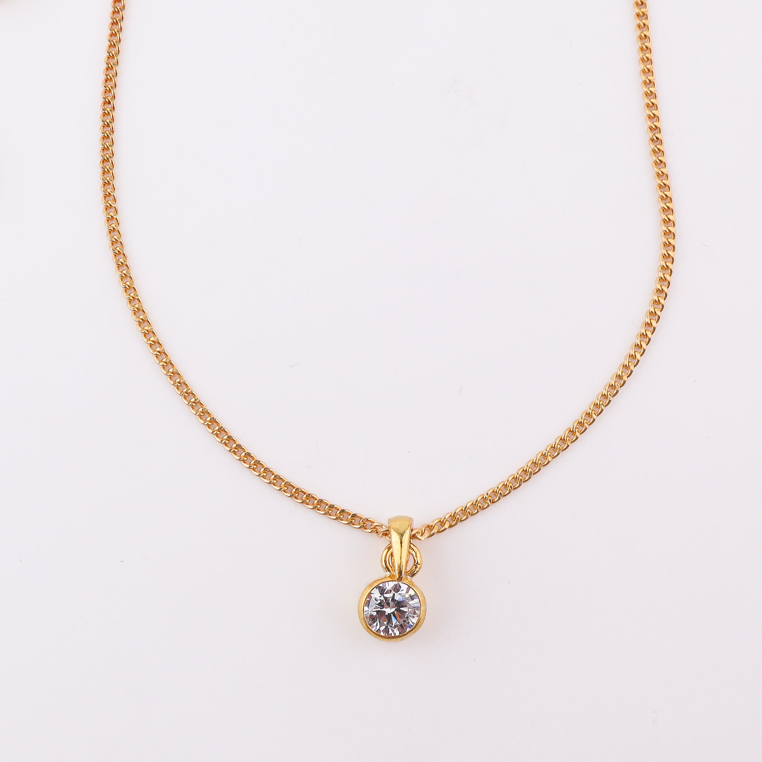 Close-up of gold chain with black cubic zirconia pendant