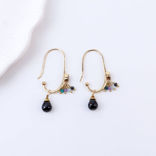 Angled view of brass fashion earrings highlighting the unique silhouette, structure, and polished brass finish
