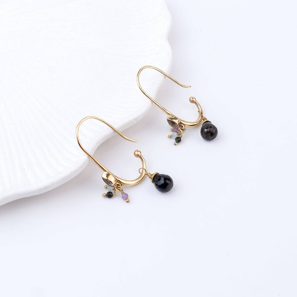Detailed view of brass fashion earrings highlighting intricate motifs, textured surface, and refined brass finish