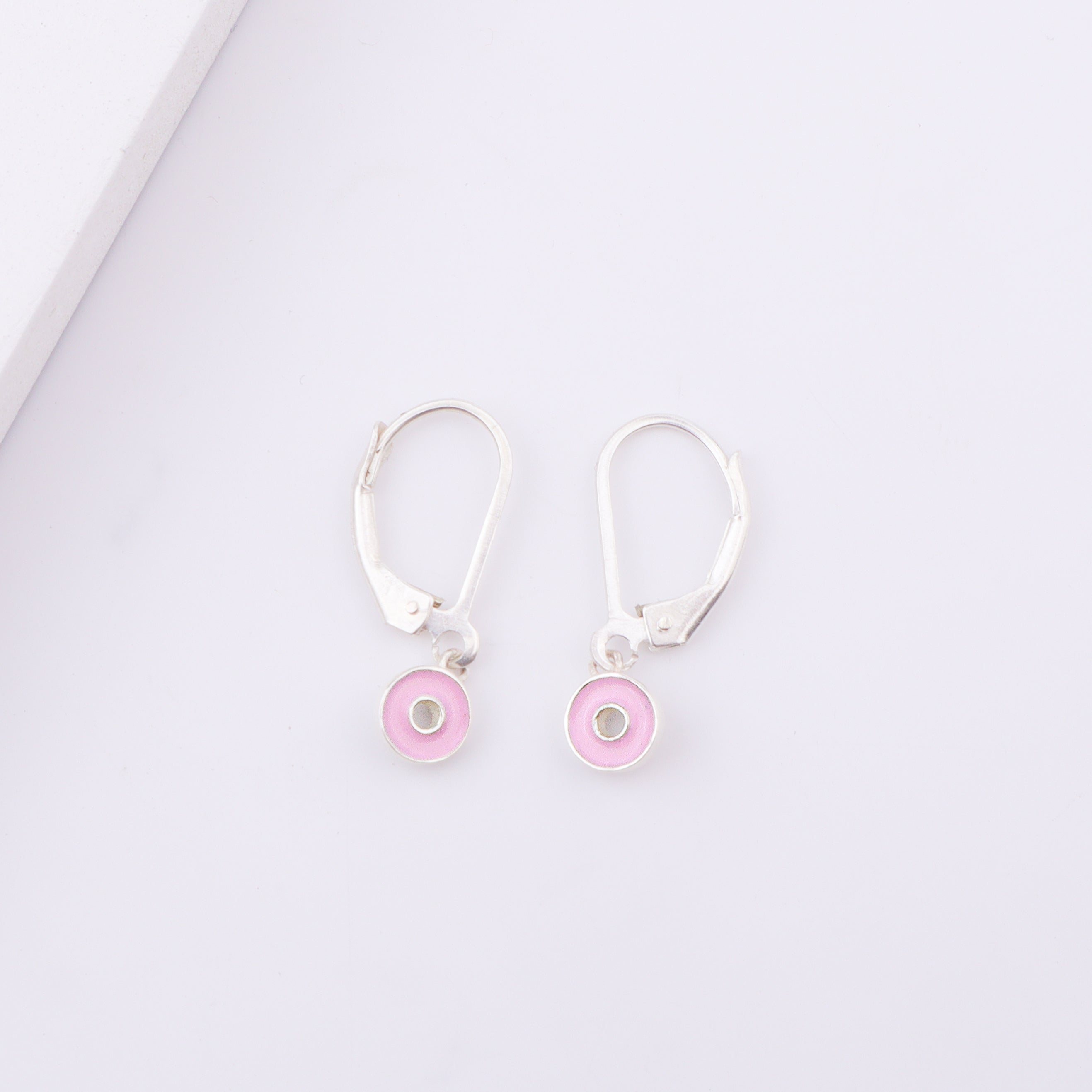 White enamel donut earrings on display