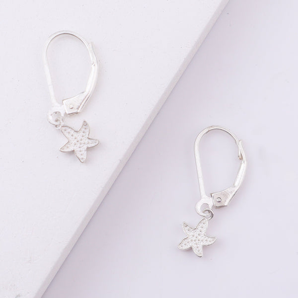 Silver starfish earrings on white background