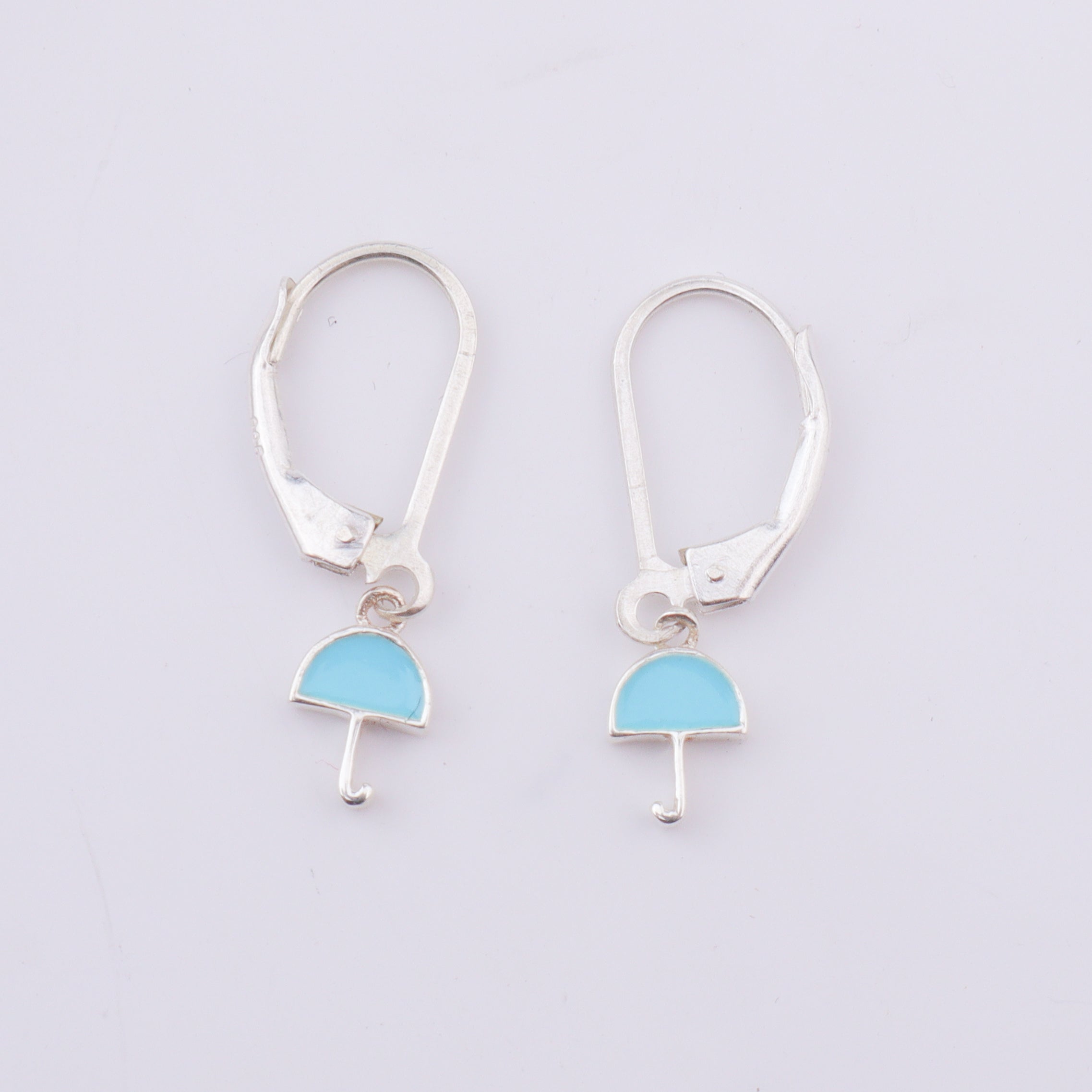 Silver enamel umbrella dangler earrings on model