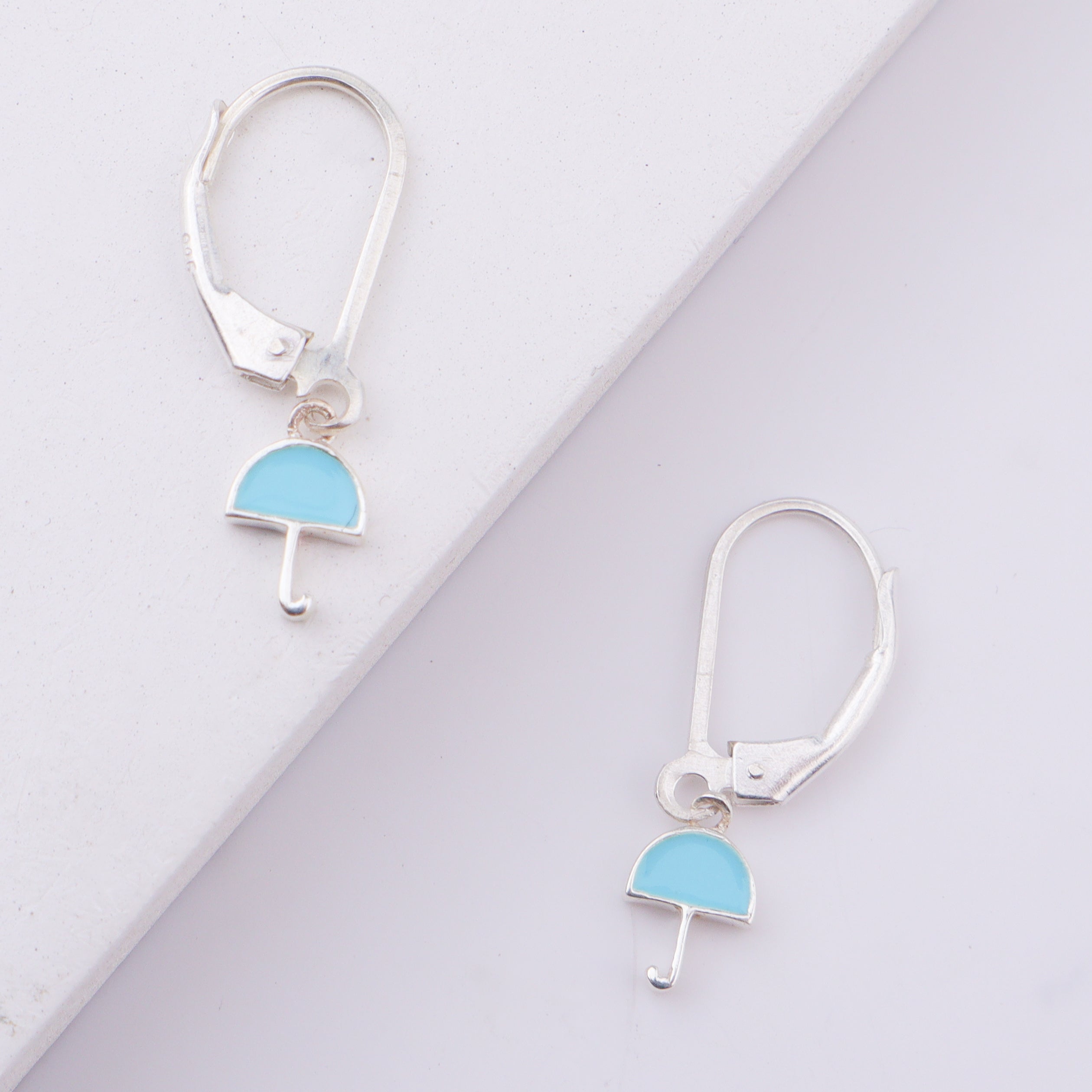 Silver enamel umbrella earrings on white background