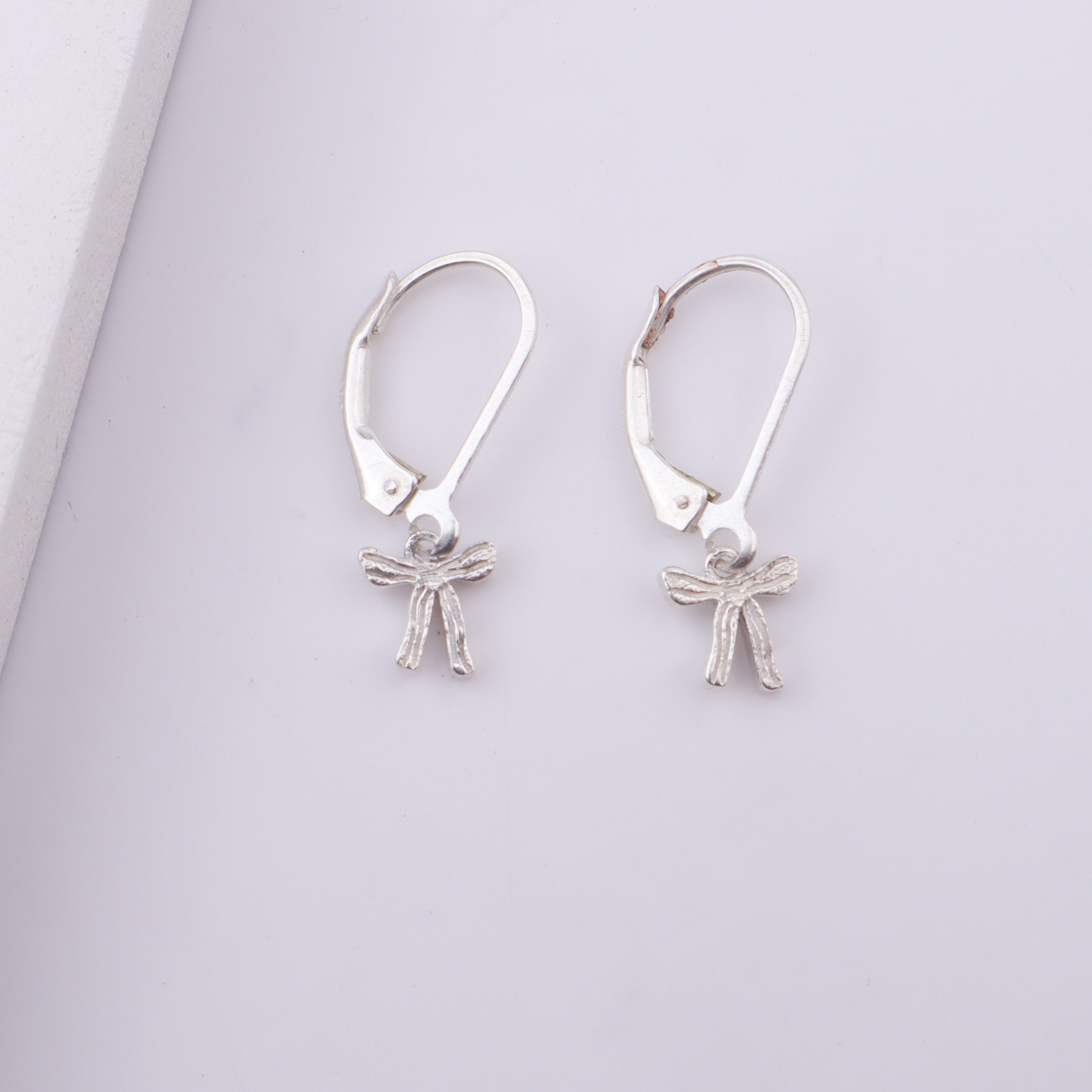 Woman wearing silver bow earrings with necklace