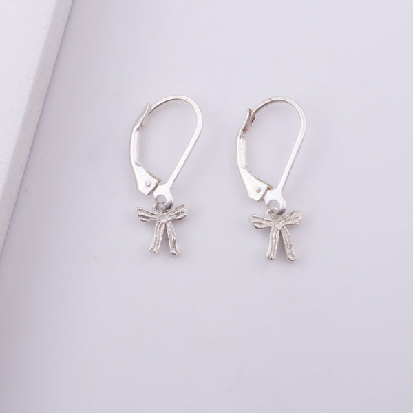 Woman wearing silver bow earrings with necklace