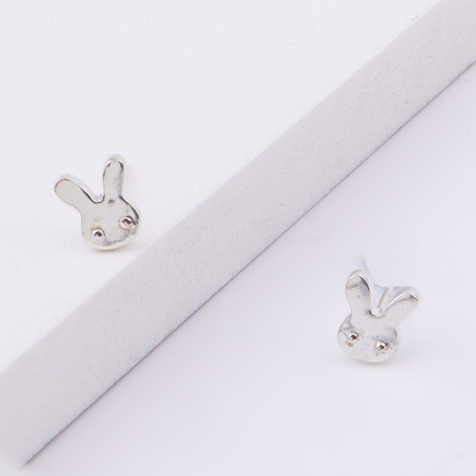 Close-up of bunny stud earrings on ear